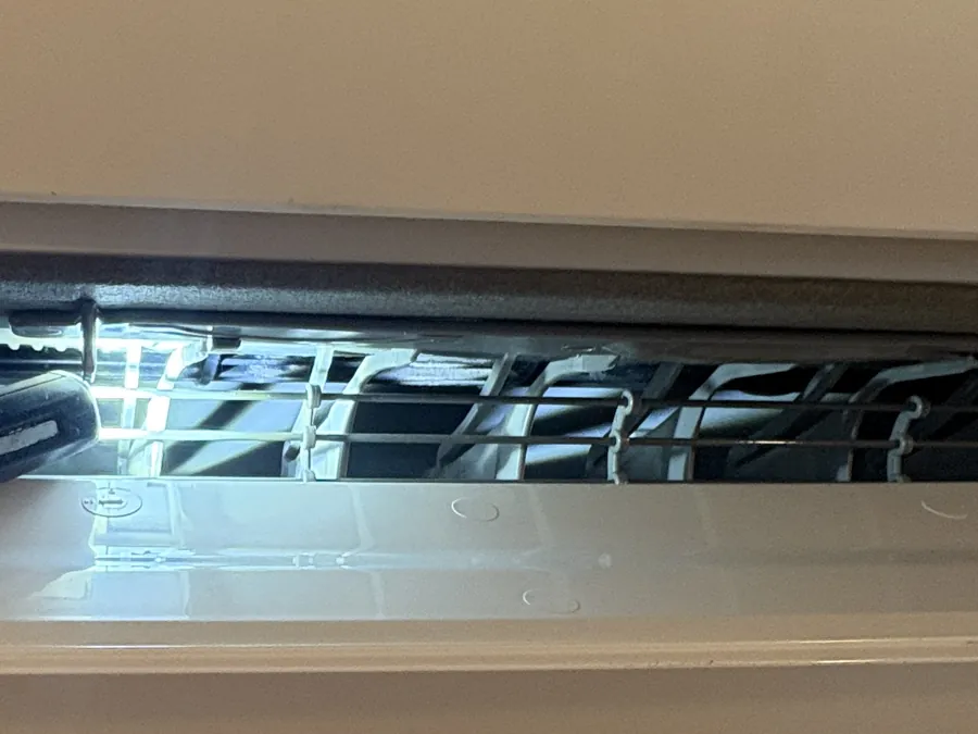 Intérieur d'un climatiseur propre éclairé à la lampe : les ailettes de l'échangeur sont nettes et régulières